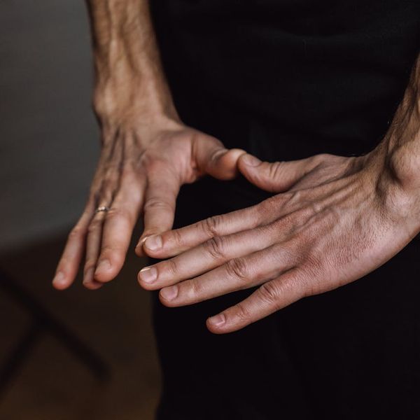 Close-up of a person's hands in a meditative mudra gesture.